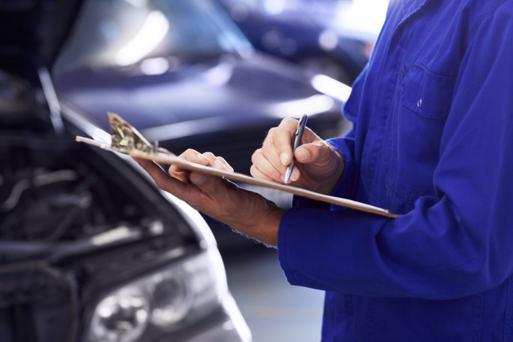 insurance adjuster inspecting a car 